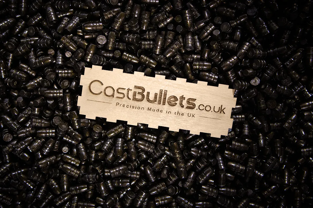 CastBullets.co.uk branding plaque resting on a bed of precision cast lead bullets, highlighting UK-made craftsmanship.