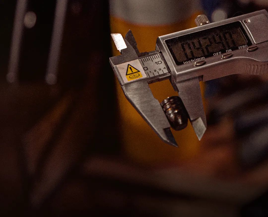 Digital caliper measuring the diameter of a cast bullet, showing precise dimensional control in UK bullet manufacturing.