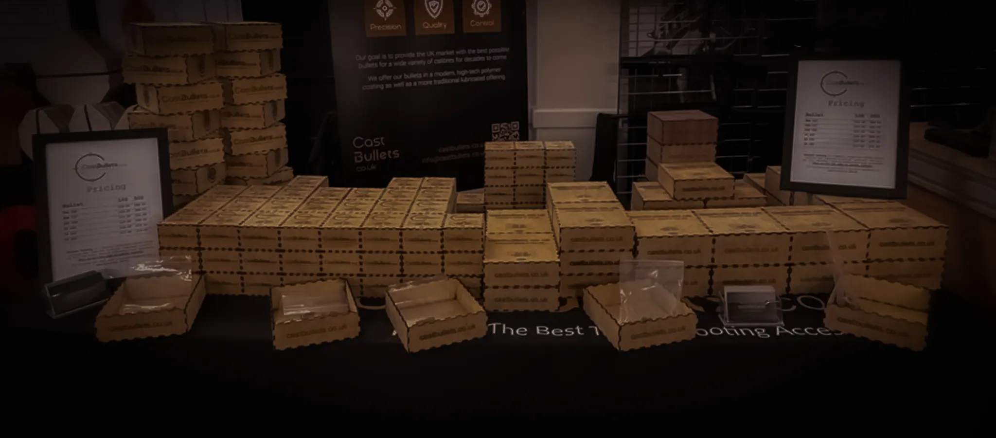 CastBullets.co.uk trade show stand displaying stacked packaging, pricing sheets and product displays at a UK shooting event.
