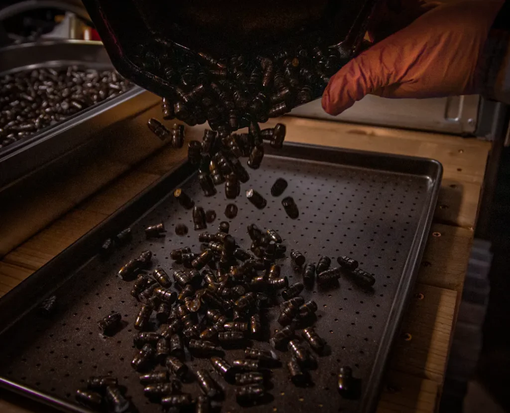 Traditional lubricated cast lead bullets being handled during UK manufacturing process